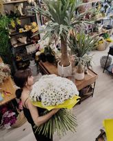 Florista de Arrels de la Vila con un gran ramo de margaritas en el taller